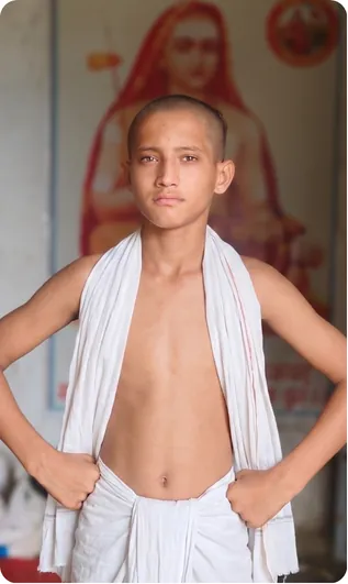 Gurukul student standing before a portrait of a saint