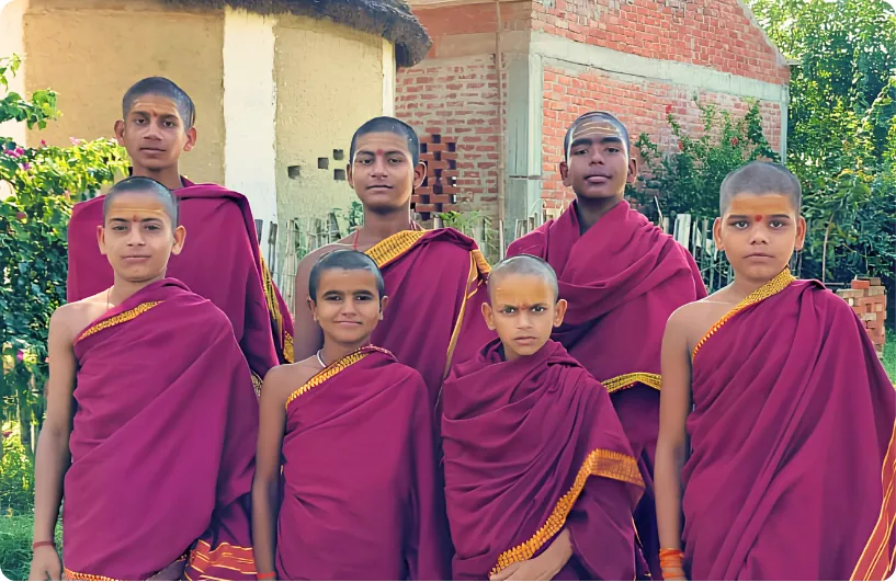 Group of students in maroon robes outside the gurukul