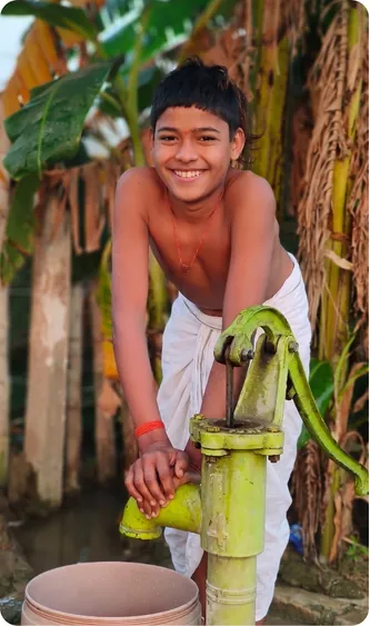 Student drawing water from a hand pump