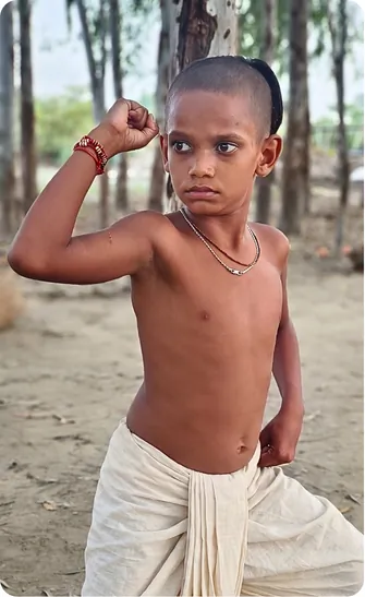 Young gurukul student flexing his arm with confidence
