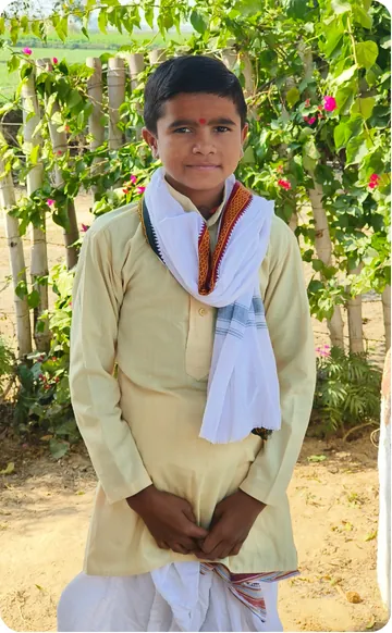 Student in a kurta standing before flowering creepers