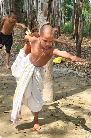 Gurukul student practising a martial arts stance in a grove